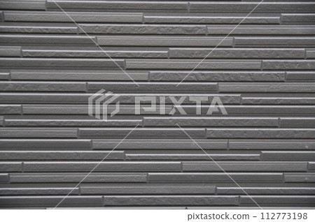 Expressive exterior wall material with uneven texture of monochrome tiles with different textures 112773198