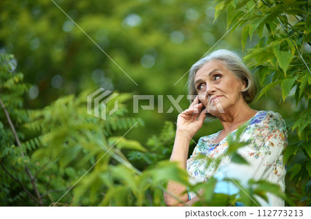 Portrait of senior woman in summer park Portrait of senior woman in summer park 112773213