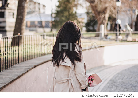 Contemplative Woman Holding Bouquet of Tulips Contemplative Woman Holding Bouquet of Tulips 112773243