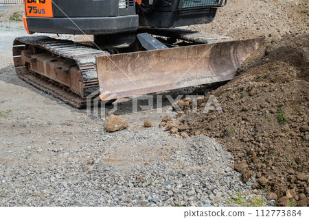 Heavy machinery leveling the soil at a construction site Heavy machinery leveling the soil at a construction site 112773884