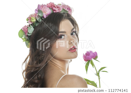 Portrait of female model in floral summer wreath on her hair. Young woman with clean skin  112774141