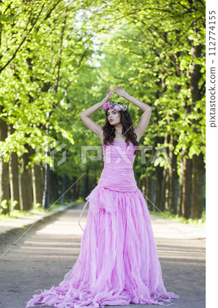 Elegant young adult lady with with long hair, make-up and pink flower 112774155