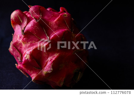 holding a dragon fruit in hand 112776078