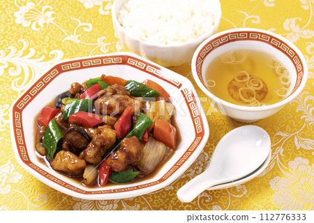 糖醋肉是一道經典的中國菜餚,盛在八角形的盤子上,上面覆蓋著黃色的中國圖案布。 糖醋肉是一道經典的中國菜餚,盛在八角形的盤子上,上面覆蓋著黃色的中國圖案布。 112776333