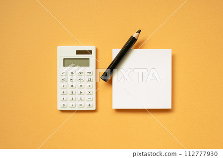 Office supply. Calculator, notepad, pencil on orange desk background. flat lay, top view, copy space Office supply. Calculator, notepad, pencil on orange desk background. flat lay, top view, copy space 112777930