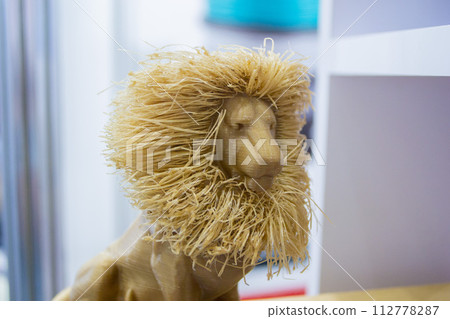 Abstract art object printed on 3D printer. Colored light brown creative model lion printed 3D printer from molten ABS PLA plastic filament. Object printed FDM printer. Additive new modern technology 112778287