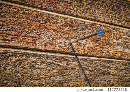 A nail sticks out of the board 112778318