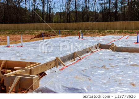 Before pouring foundation for house, ground is covered with first layer of insulation waterproofing. 112778626