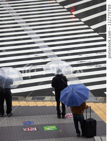雨天城市十字路口人行道處等待紅綠燈的上班族的高角度鏡頭 112778789