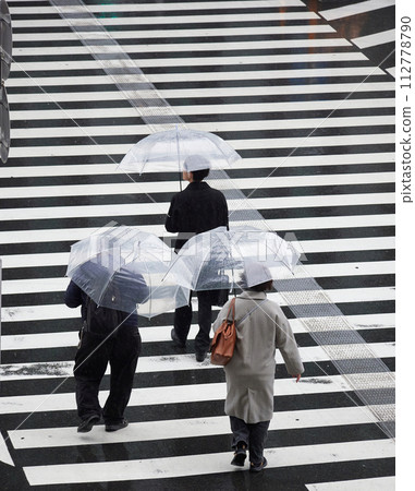 下雨天人們穿過城市十字路口人行道的高角度鏡頭 112778790