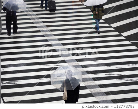 下雨天人們穿過城市十字路口人行道的高角度鏡頭 112778792
