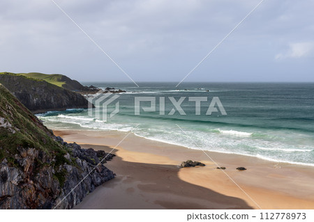 Durness Beach in Scotland: a dramatic union of rugged cliffs, pristine sands, and emerald waves Durness Beach in Scotland: a dramatic union of rugged cliffs, pristine sands, and emerald waves 112778973