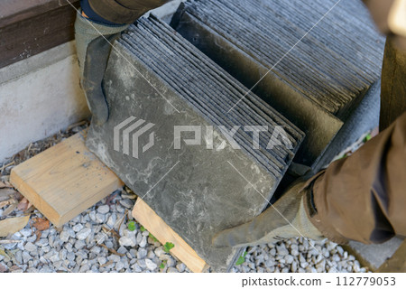 Craftsman carrying roofing material (slate) Craftsman carrying roofing material (slate) 112779053