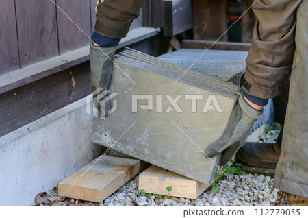 Craftsman carrying roofing material (slate) 112779055