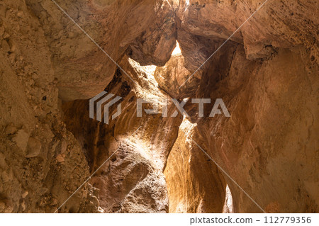 Karadakh gorge. Sunlight in a mountain Canyon. Beautiful curved crevice in sunny weather. Creation erosion of yellow sandstone by water acquired twisted shape natural Origin. Dagestan, Russia, Europe 112779356