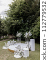 wedding arch for the ceremony with white chairs 112779532