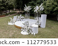 wedding arch for the ceremony with white chairs 112779533