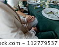 the bride and groom hold hands at the banquet 112779537