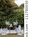 a wedding cake near arch for the evening ceremony 112780030