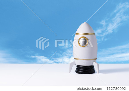 Toy rocket of spaceman. Space shuttle on table over blue background with copy space. Kids dream about future space flying concept. 112780092