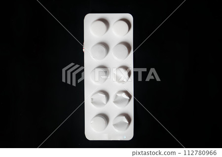 A white pill bottle with a black background 112780966