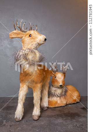 Reindeer Figurines with Silver Antlers on Gray Background for Festive Holiday Display Reindeer Figurines with Silver Antlers on Gray Background for Festive Holiday Display 112781945