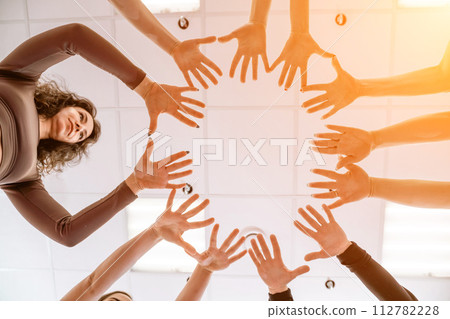 Team of people holding hands. Group of happy young women holding hands. Bottom view, low angle shot of human hands. Friendship and unity concept Team of people holding hands. Group of happy young women holding hands. Bottom view, low angle shot of human hands. Friendship and unity concept 112782228