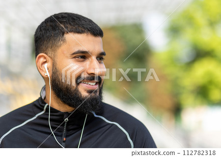 A man pauses his workout to enjoy a moment of rest outdoors, showcasing a lifestyle of health and fitness. 112782318