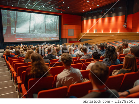 AI-generated content. Audience is watching the speaker on stage at an event or conference 112782503