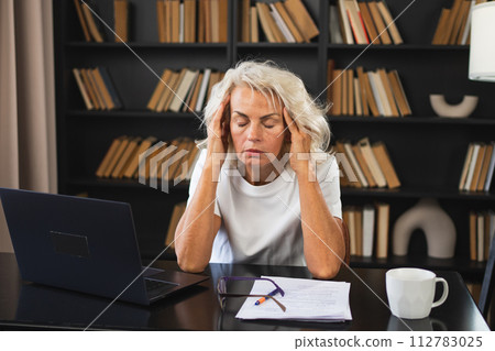 Headache pain. Middle aged woman touching temples experiencing stress. Mature old lady tired of work feeling headache sick rubbing temples forehead. Long laptop usage computer vision office syndrome 112783025