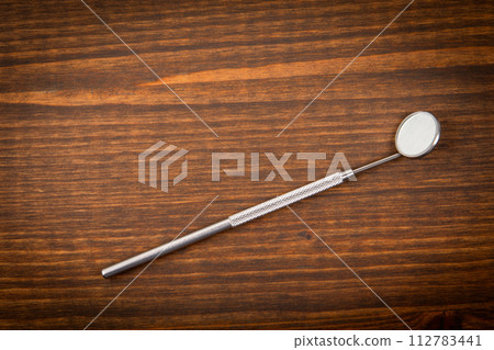 Dentist and dental hygienist mirror on wooden background 112783441