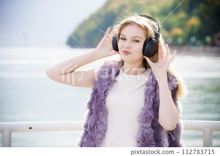 Happy woman wearing headphones outdoor 112783715