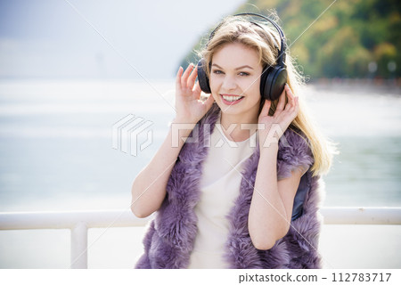 Happy woman wearing headphones outdoor 112783717