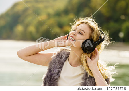 Happy woman wearing headphones outdoor Happy woman wearing headphones outdoor 112783718