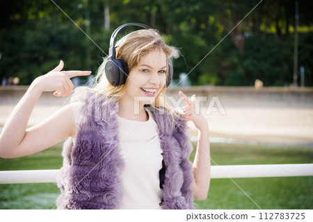 Happy woman wearing headphones outdoor Happy woman wearing headphones outdoor 112783725
