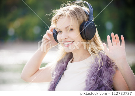 Happy woman wearing headphones outdoor Happy woman wearing headphones outdoor 112783727