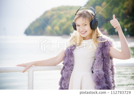Happy woman wearing headphones outdoor Happy woman wearing headphones outdoor 112783729