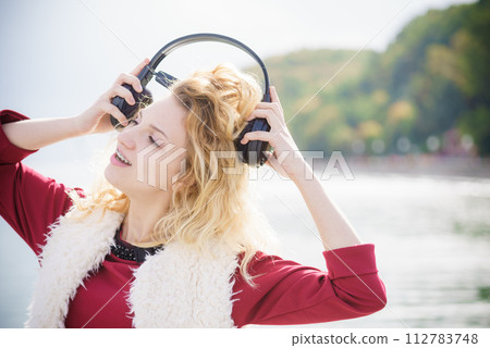 Happy woman wearing headphones outdoor Happy woman wearing headphones outdoor 112783748