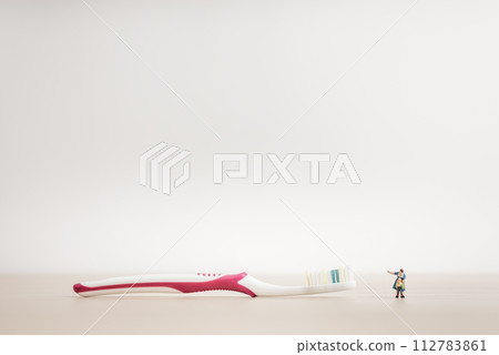Little kid and mom looking at a giant toothbrush Little kid and mom looking at a giant toothbrush 112783861