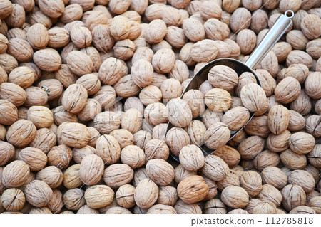 A scoop of walnuts, a superfood, rests on a stack of nuts seeds A scoop of walnuts, a superfood, rests on a stack of nuts seeds 112785818