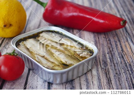 Canned sardines. Sea fish in tin can on kitchen table. Canned sardines. Sea fish in tin can on kitchen table. 112786011