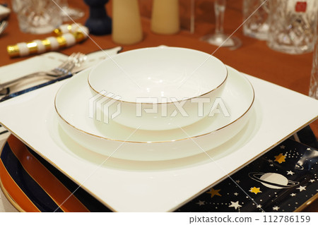 round bowl or ceramic plate on napkin on wooden table. round bowl or ceramic plate on napkin on wooden table. 112786159
