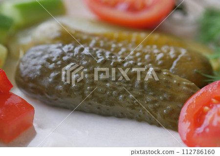 a close up of a pickle on a plate with tomatoes a close up of a pickle on a plate with tomatoes 112786160