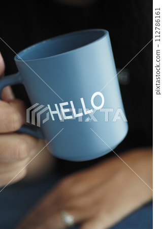 women holding a blue coffee cup with hello word women holding a blue coffee cup with hello word 112786161