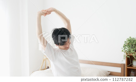 A man wakes up and stretches A man wakes up and stretches 112787282