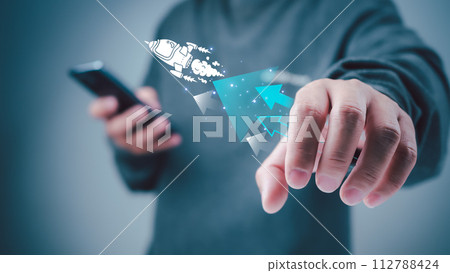 Start up business concept to success, Man holding smartphone and white rocket icon is launch and soar flying out from screen with network digital technology, Finance business growth concept. 112788424