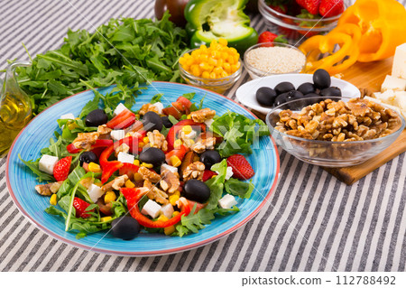 Salad with arugula, olives, Feta cheese, corn and walnut and its ingredients Salad with arugula, olives, Feta cheese, corn and walnut and its ingredients 112788492