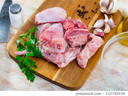 Portioned rabbit legs and saddle with herbs and spices Portioned rabbit legs and saddle with herbs and spices 112788556