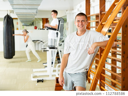 Positive man standing at ladder in gym 112788586