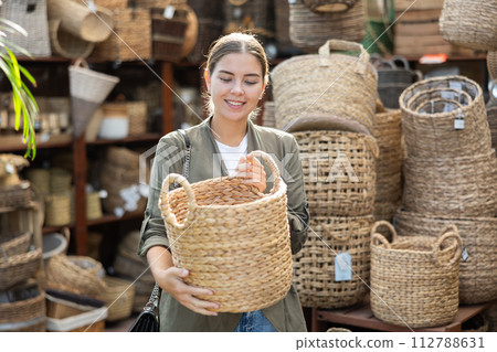 Young woman choosing basket in store Young woman choosing basket in store 112788631